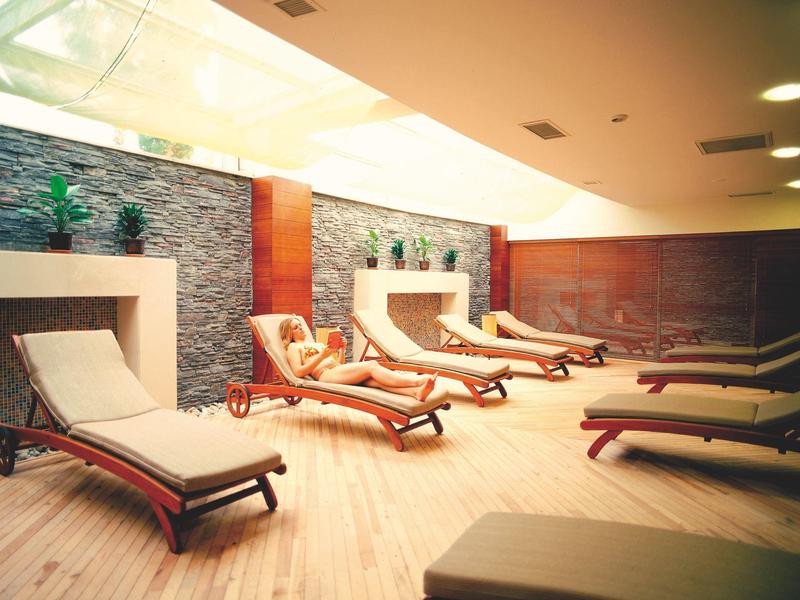 Espace bien-être intérieur avec chaises longues et ambiance relaxante.