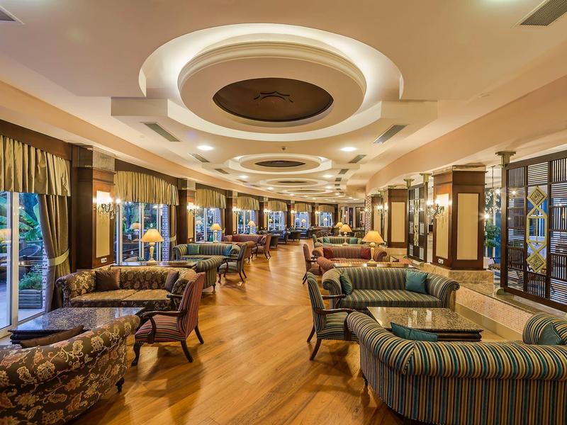 Grand salon d'hôtel élégant avec fauteuils élégants et sol en bois