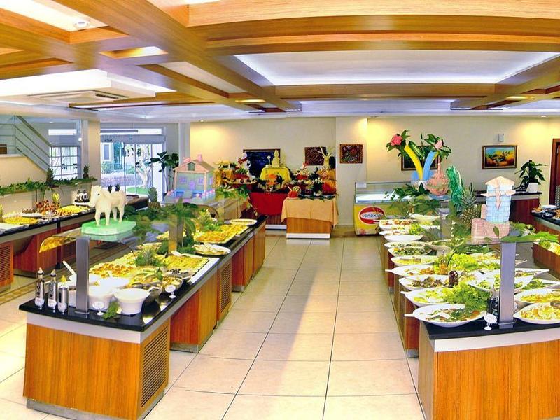 Großes Buffet-Restaurant mit verschiedenen Speiseinseln, hellem Licht und modernen Deckenlampen.