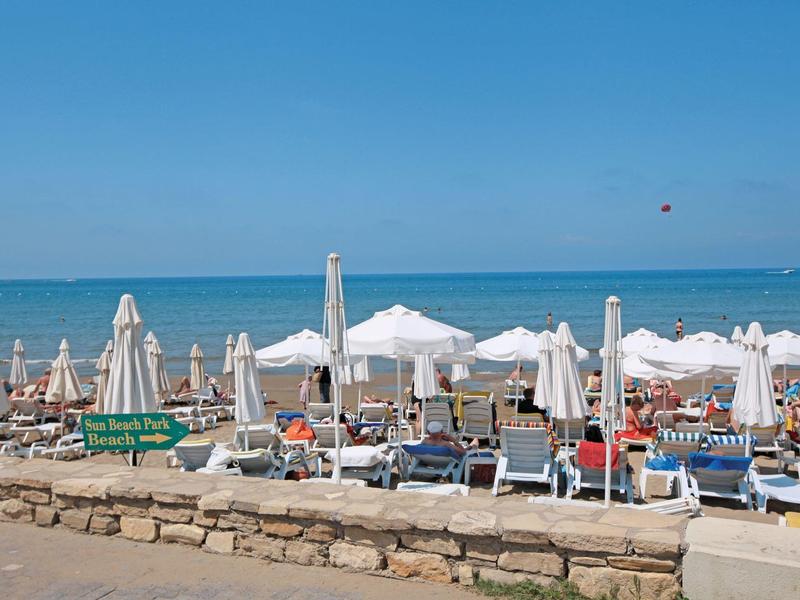 Spiaggia con ombrelloni, lettini e mare blu sullo sfondo