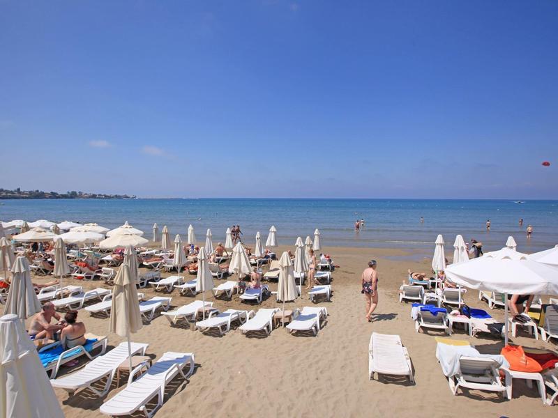 Spiaggia con lettini e ombrelloni vicino al mare sotto un cielo azzurro limpido