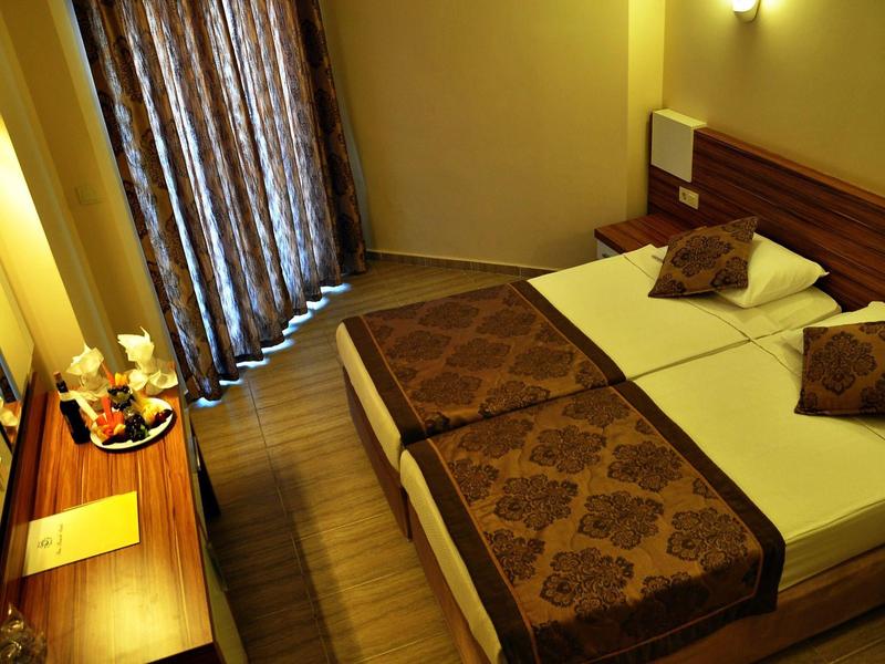 Camera d'hotel accogliente con letto grande, accenti marroni e pavimento in legno.