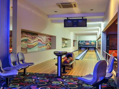 Modern bowlingcentrum met twee banen en kleurrijk tapijt.