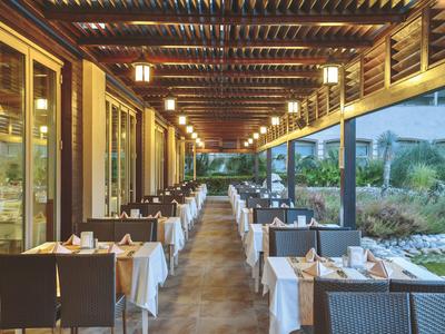 Elegant gedekte tafels onder een overdekt buitengedeelte van een restaurant met sfeerverlichting.