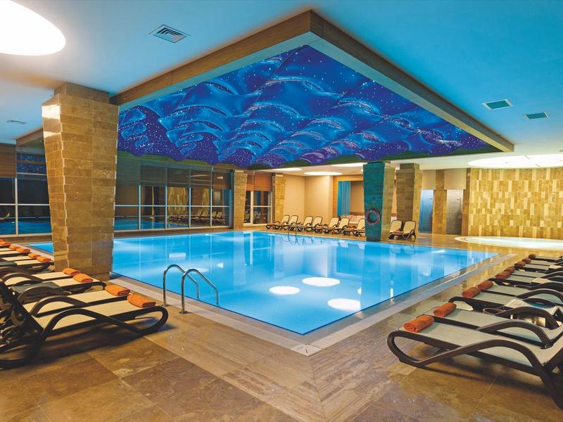 Luksusowy basen kryty z leżakami i ciepłym oświetleniem.