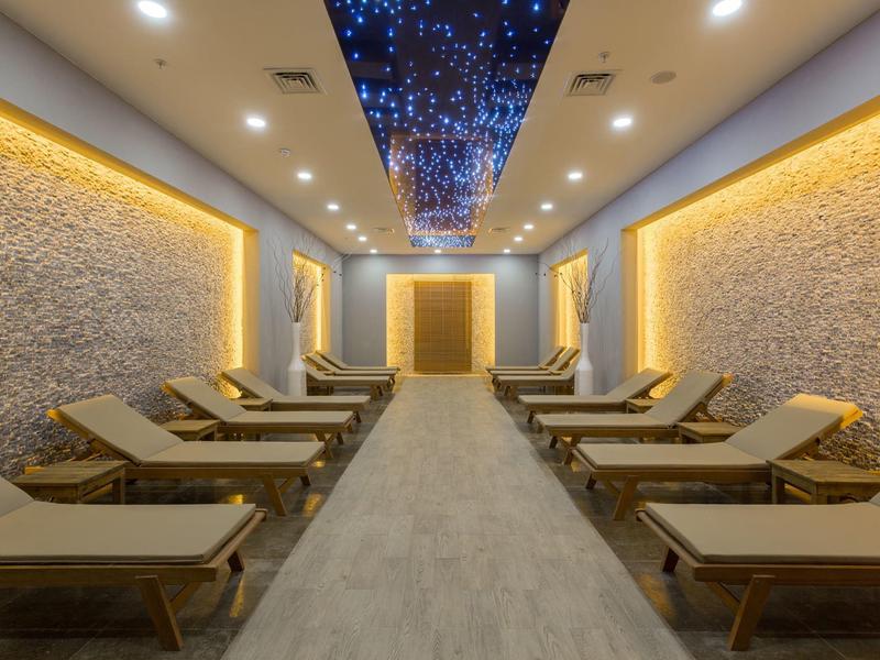 Nowoczesny pokój relaksacyjny z leżakami i sufit z efektem gwiazd.