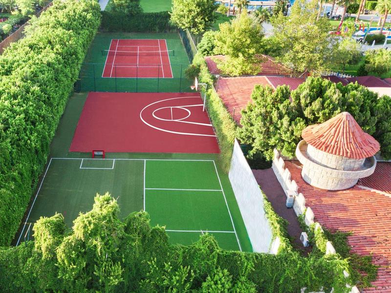 Zewnętrzne boiska sportowe otoczone zielenią w hotelu lub ośrodku wypoczynkowym.