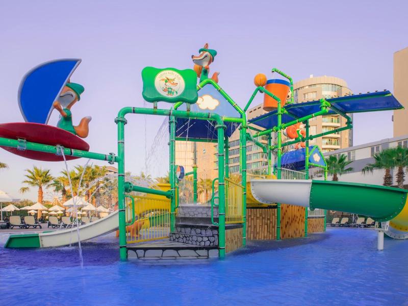 Kolorowy plac zabaw wodny z zjeżdżalniami na nowoczesnym hotelowym terenie na zewnątrz.