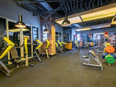 Ampia palestra con attrezzature moderne e pesi colorati in un hotel.