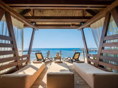 Lettini lounge di lusso con posti a sedere e vista sul mare sulla spiaggia.