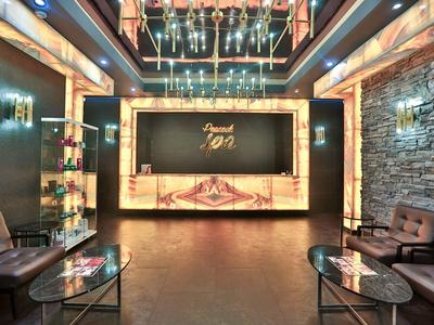 Moderna recepción de hotel con sillones de cuero, mesas de cristal y mostrador iluminado cálidamente.