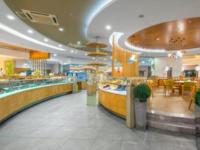 Restaurante buffet moderno y luminoso con mostradores curvos y área de comedor.