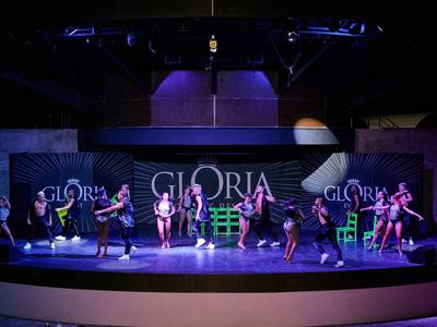 Pódium s několika tanečníky předvádějícími barevný tanec v hotelu Gloria