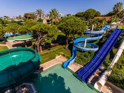Waterpark met drie glijbanen omgeven door weelderig groen.
