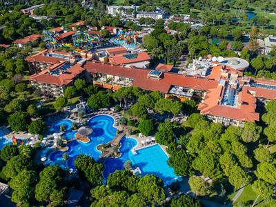Grande hotel con più piscine circondato da abbondante vegetazione e alberi in una zona tranquilla.