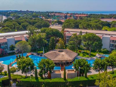 Blick auf ein Resort mit Pool, Palmen und mehreren Gebäuden, ideal für einen Urlaub.