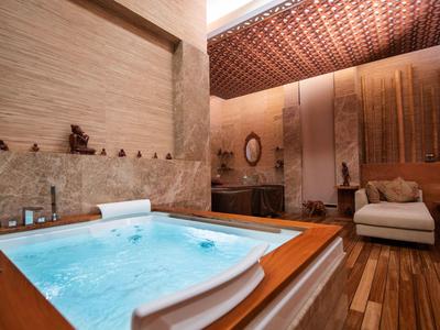 Luxuriöses Hotelzimmer mit Whirlpool, Holzboden und moderner, warmer Beleuchtung.