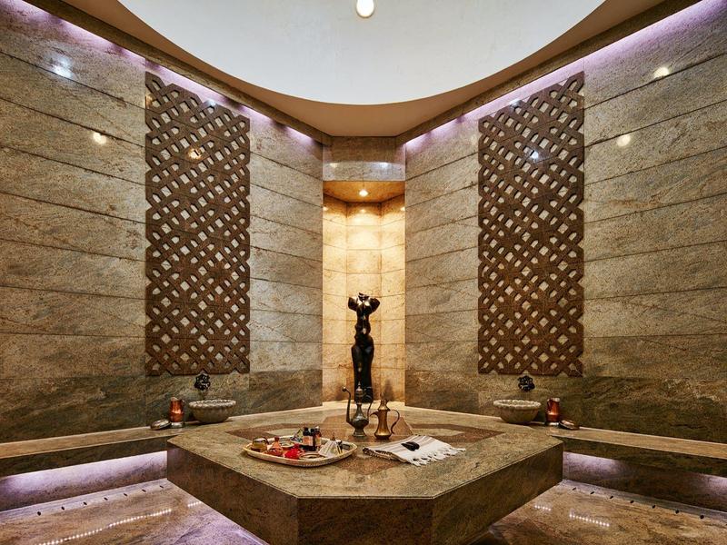 Elegancki pokój spa z artystyczną dekoracją i centralną fontanną wodną.