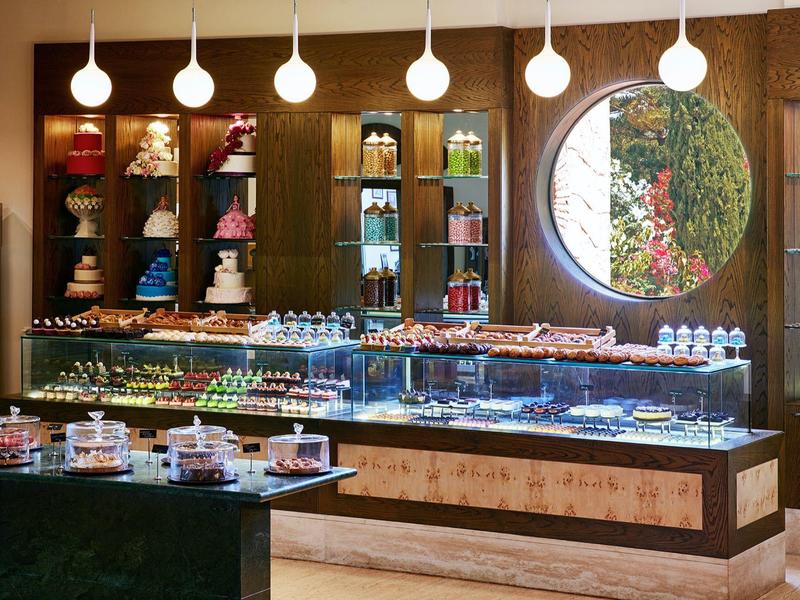 Nowoczesna piekarnia z podświetlanymi witrynami i okrągłym oknem z widokiem na ogród