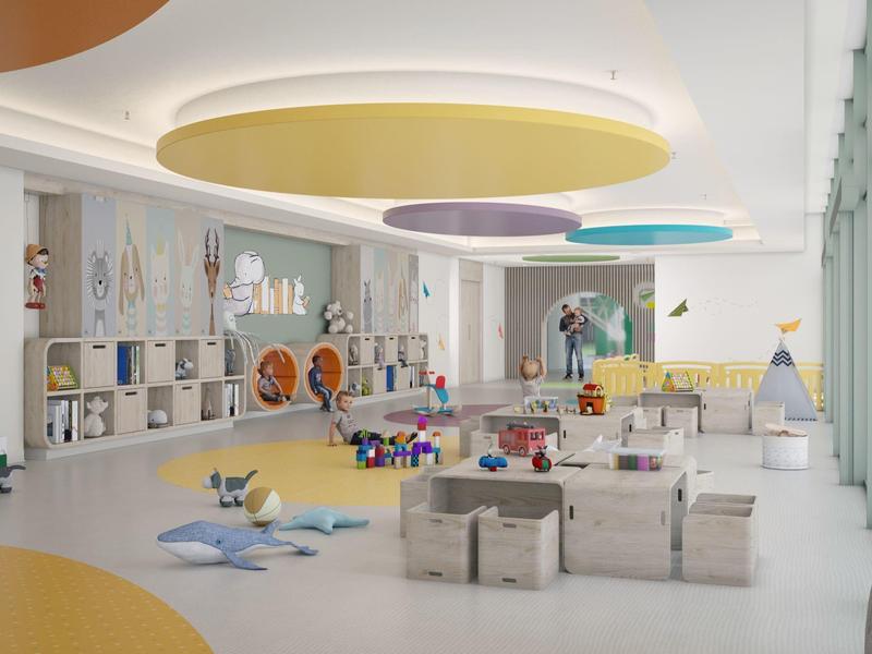 Duża, jasna sala zabaw dla dzieci z kolorowymi lampami sufitowymi i zabawkami na podłodze.