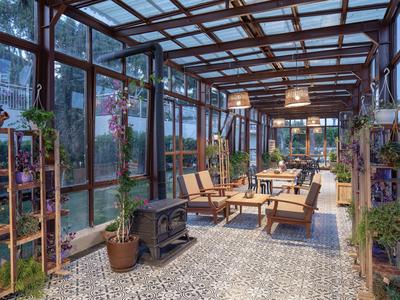 Véranda confortable avec sièges et de nombreuses plantes à l'hôtel.