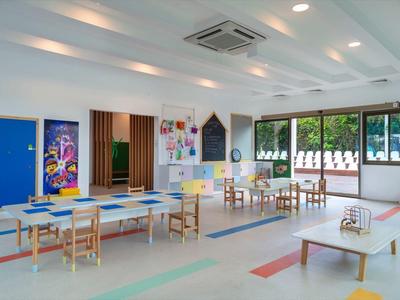 Grande salle de jeux lumineuse avec tables, chaises et jouets colorés dans un hôtel