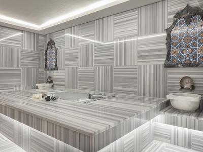 Modern steam room with geometric patterned walls and illuminated seating areas.