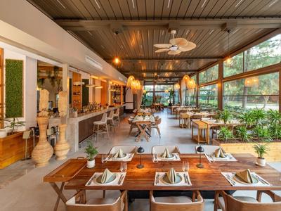 Modern, bright restaurant with wooden tables and large windows providing a pleasant atmosphere.