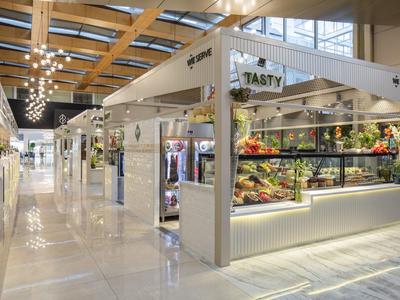 Bright, modern market with fresh fruits and vegetables in a spacious building.