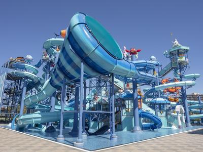 Water park with large blue water slides under a clear blue sky.