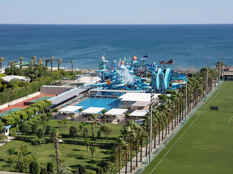 Vue d'une station de parc aquatique au bord de la mer avec piscines et toboggans.