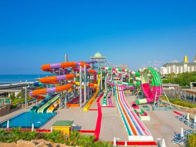 Kleurrijk waterpark met glijbanen en attracties op een zonnige dag aan zee.