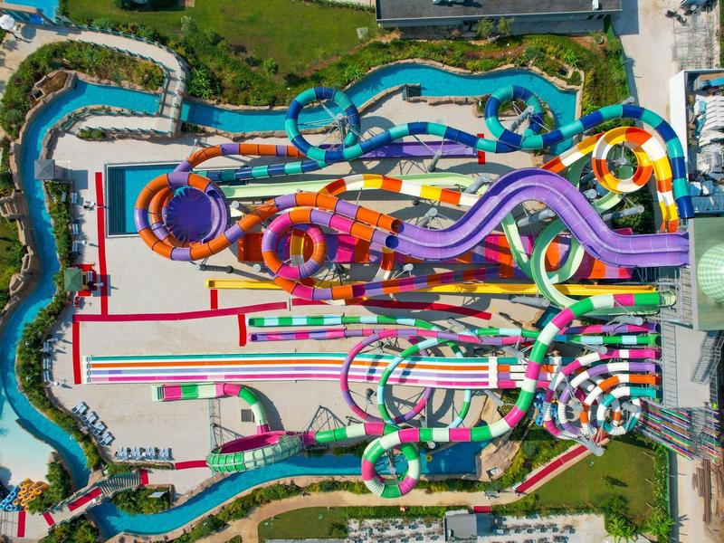 Kleurrijke waterglijbanen vanuit vogelvlucht met groen en paden