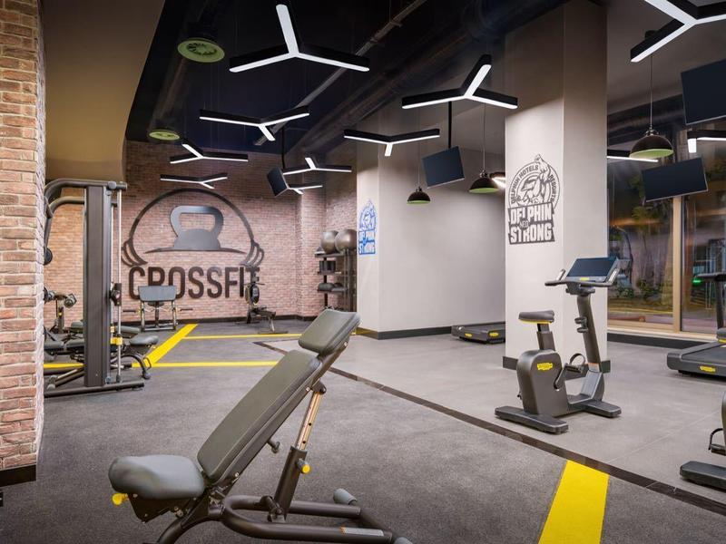 Moderne Crossfit-sportruimte met halters, trainingsbank en cardioapparaten.