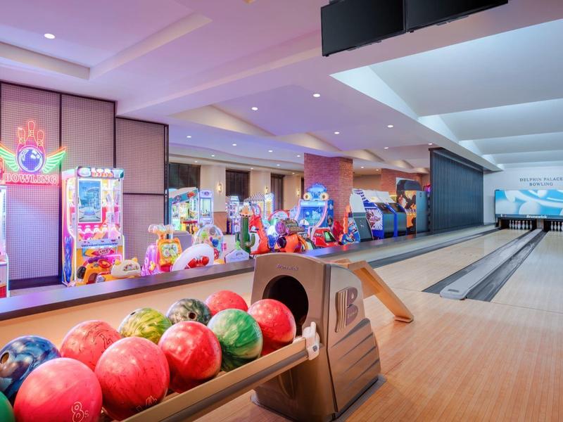 Moderne bowlingbaan met kleurrijke bowlingballen en levendige automaten op de achtergrond.