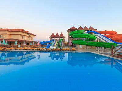 Piscina con scivoli d'acqua accanto agli edifici dell'hotel sotto un cielo sereno alla sera