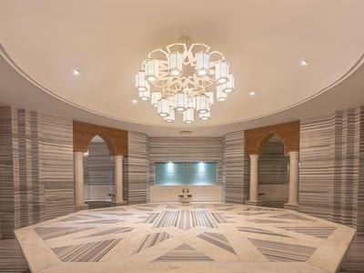 Duży okrągły hol z marmurową podłogą i eleganckim żyrandolem