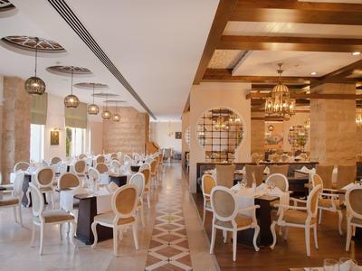 Elegancka restauracja z wygodnymi białymi krzesłami i ciepłym drewnianym wystrojem.