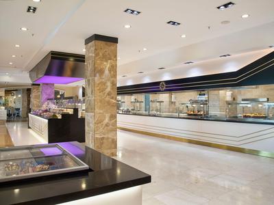 Geräumiger moderner Buffetbereich mit weißen Böden und schwarzen Theken in einem Hotel.