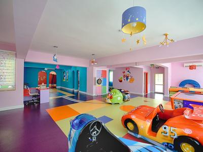 Kolorowy, przestronny pokój zabaw dla dzieci z zabawkowymi samochodami i miejscami do siedzenia.