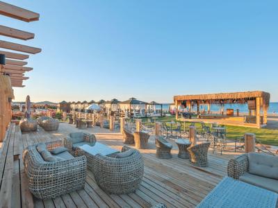 Przytulny teren na zewnątrz z meblami z rattanu z widokiem na plażę hotelową.