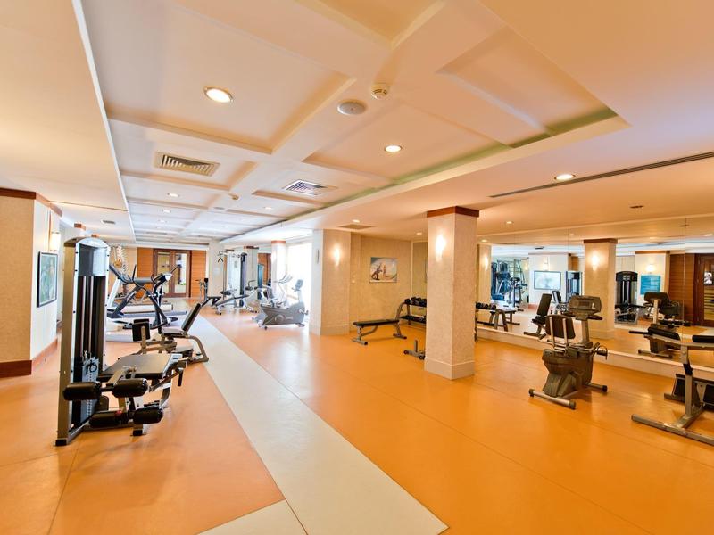 Przestronna siłownia z nowoczesnym sprzętem i jasnym oświetleniem w hotelu.