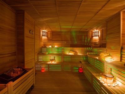 Sauna con bancos de madera y luces cálidas, ambiente relajante en un hotel o spa.
