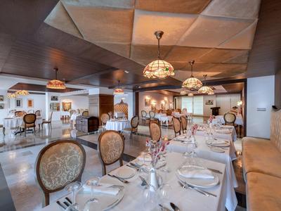 Restaurante elegante con mesas puestas, sillas cómodas y luz cálida.