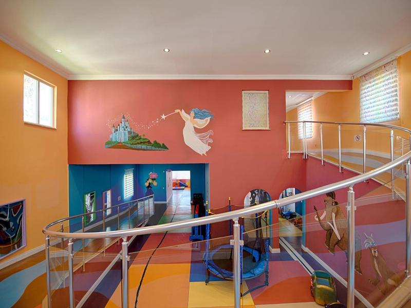 Interior de hotel colorido con escalera, ventanas, paredes pintadas y diseño moderno.