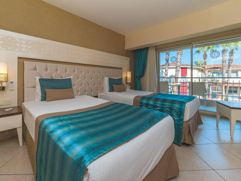 Habitación de hotel luminosa con dos camas y ventana grande con vistas al exterior