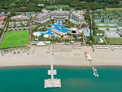 Luksusowy hotel nad morzem z basenami, parasolami i molo wychodzącym na czystą wodę