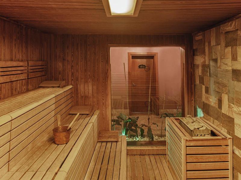 Wnętrze sauny z drewnianą boazerią i szklaną ścianą
