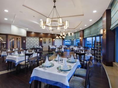 Ristorante d'hotel elegante con tavoli apparecchiati e lampadari moderni.