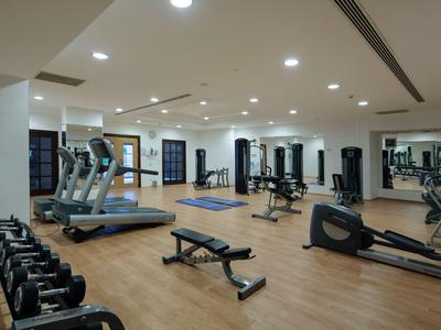 Palestra moderna con vari attrezzi e pavimento in legno in un hotel.